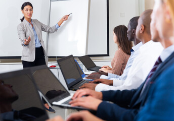 Female speaker giving talk on corporate business meeting in meeting room
