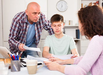 Casual family with teenage son working with papers at home