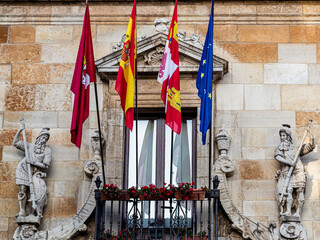 Fototapeta na wymiar Official flags on the main facade of the Guzmanes Palace, León, Castilla y León, Spain.