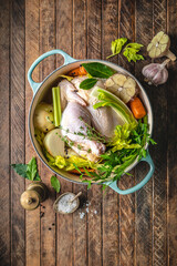 Raw chicken pieces and vegetables in Dutch oven for chicken stock