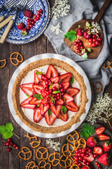 Obraz na płótnie Canvas Flat lay of strawberry Cream Pie in ceramic dish with fresh berries and pretzels