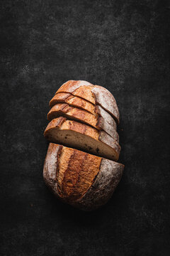 Rustic sliced sourdough loaf with bread knife.