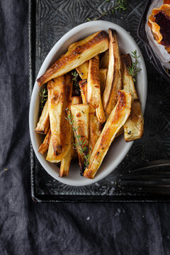 Bowl of roast parnsips served as a side dish.