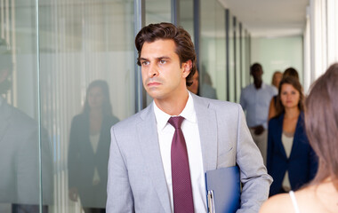 Portrait of successful businessman in formal suit walking through office