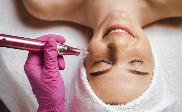 Top view of freckled woman getting hardware cosmetology treatment at spa. Dermatology, cosmetology. Girl facial treatment. Skin care.