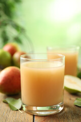 Fresh pear juice in glass on wooden table, closeup