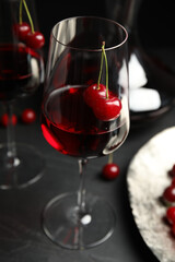 Delicious cherry wine with ripe juicy berries on grey table
