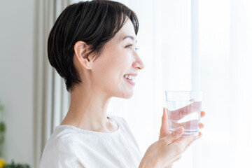 水の入ったコップを持った日本人女性