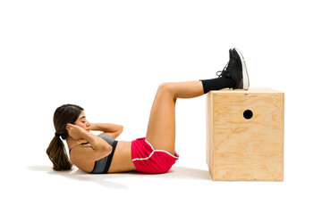 Attractive woman training with abdominal crunches with a plyo box