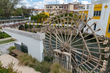 Old water wheel and buildings by River Almonda in the old city of Torres Novas, Portugal