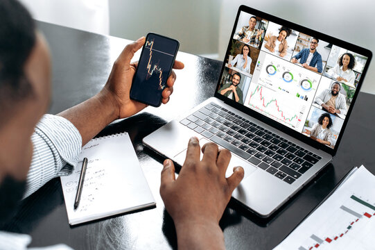 Successful african american male crypto trader, holding an online video conference with multiracial colleagues, discussing and analyzing the stock market, possible risks, rise and fall