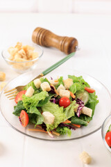 Fresh Salad with Cherry Tomatoes, Carrot, Romaine, and Lettuce in a Plate on White Wooden Background
