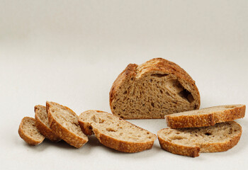 Bread, Traditional Sourdough Bread Cut into Slices on a Cream Light Background.