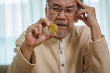 Senior man hold Bitcoin and stress due to losses from trading Bitcoin,Cryptocurrency trading concept.