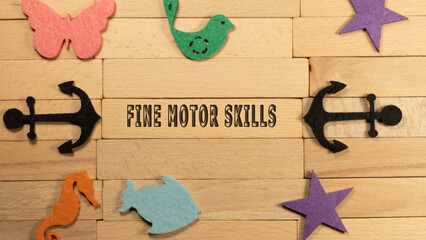 Fine motor skills written on wood patterned surface. Education and child psychology