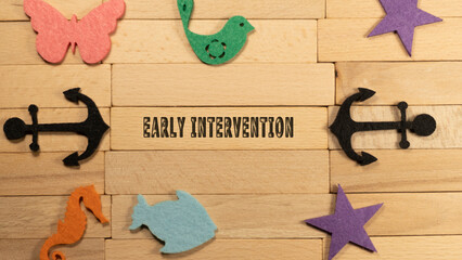 Early intervention written on wood patterned surface. Education and child psychology - obrazy, fototapety, plakaty