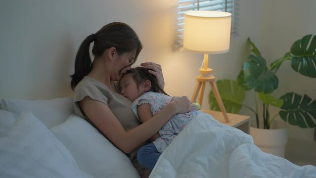 Asian beautiful mother hug sleeping baby girl in her arms with gently. 