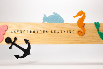 Asynchronous learning is written on a wooden patterned surface. Education and child psychology