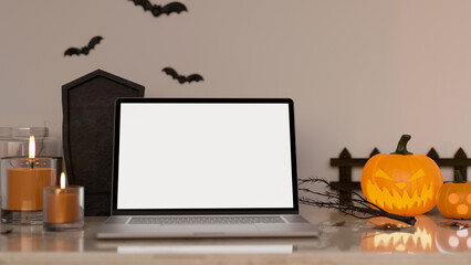 Workspace in Halloween theme with notebook laptop white screen mockup and Halloween decor