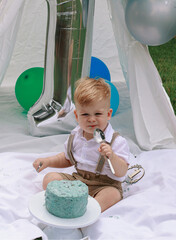 Childs first birthday party in the garden with cake and balloons 