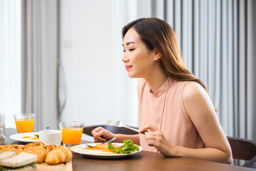 Obraz na płótnie Canvas Woman eat fresh breakfast served food with beverage before go to work in the morning at home, Asian young female sitting kitchen table food having eating healthy breakfast at home