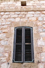 Fototapeta na wymiar A small window on the facade of a large residential building.