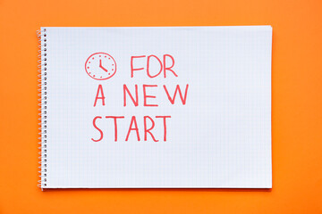 Notebook with text FOR A NEW START on orange background