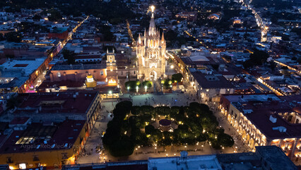 Obraz premium the church Parroquia Archangel Jardin Town Square Night Tree Decoraciones San Miguel de Allende, México. Parroaquia. Night and morning light in a drone view.