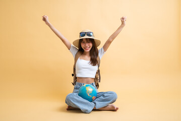 Full length of young attractive Asian woman traveler in casual clothes wearing straw hat with sunglasses, backpack and globe, Tourist girl having cheerful holiday trip concept