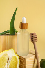 Composition with bottle of essential oil, aloe leaves and lemon on color background, closeup