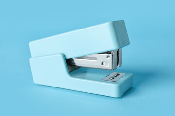 Blue stapler on color background