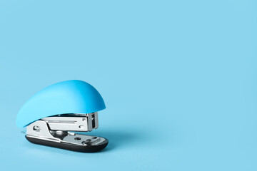 Blue stapler on color background