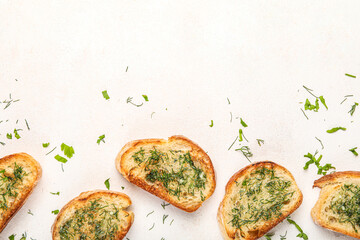 Slices of delicious toasted garlic bread with greens on light background