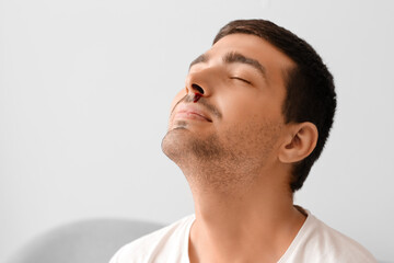 Obraz premium Young man with nosebleed at home, closeup