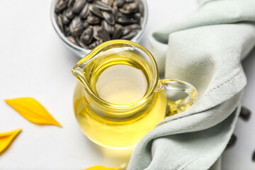 Jug of sunflower oil on white background, closeup