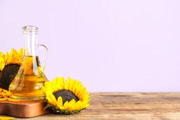Board with decanter of oil and sunflowers on wooden table