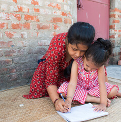 Mother teaching Hindi to daughter on her lap. Homeschooling, Happy teacher day and promote Hindi...