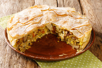Chicken Bastilla pastilla shredded chicken with aromatic spices wrapped in perfectly crisp pastry layers closeup in the plate on the table. Horizontal © FomaA