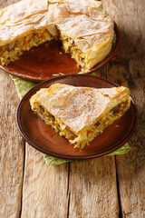 Fresh baked traditional Moroccan Pastilla or chicken bastilla closeup in the plate on the table. Vertical