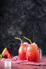Fresh drink with watermelon and mint, cold summer lemonade, healthy cocktail. Sunny day with shadows, with copy space. Wide banner mockup, organic drink on pink table and black background