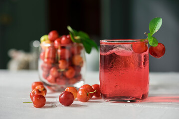 Glass of sour cherry juice with fresh red cherries, Cherry juice, on wood background, red drink, High vitamin C and antioxidant fruits.