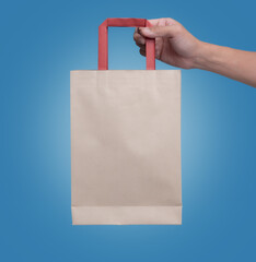 Shopping Bag,Male hand holding paper bag on blue