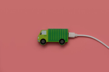 Green technology car electric vehicle,Toy car with a charger on a pink background