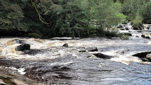 Panning of Falls of Dochart in Killin, Scotland, UK after rain with muddy water in 4K slow-motion