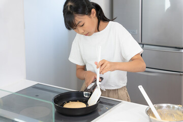 自宅のキッチンで料理をしているアジア人の女子