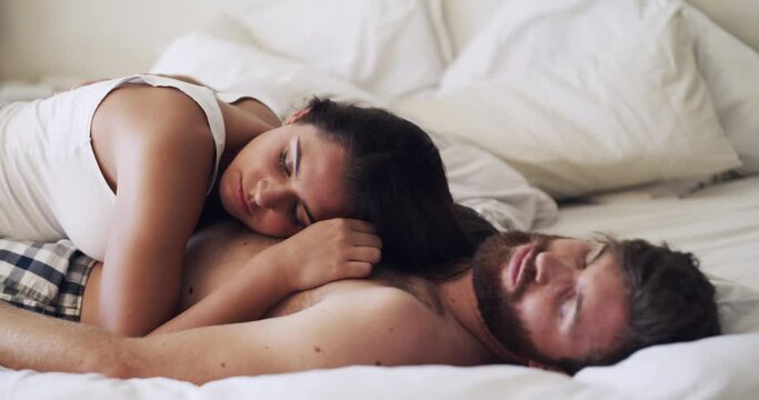 The sweetest love makes the sweetest dreams. Shot of a happy young couple having a nap in bed together at home.