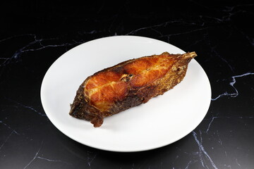 Traditional deep fried Butterfish (Silver Pomfet) filet serving on the plate. Famous seafood steak menu in Asian restaurant.  