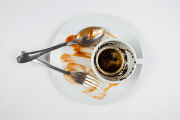 dirty dishes on a white background. Top view dirty plate, cup and fork with spoon
