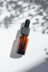 Amber bottle with cannabis oil used for medical purposes. White background with daylight and...
