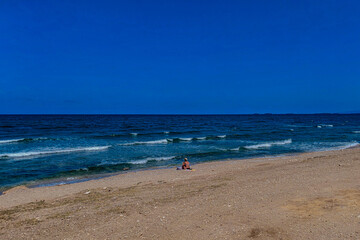 Fototapeta na wymiar a girl sitting on the seashore
